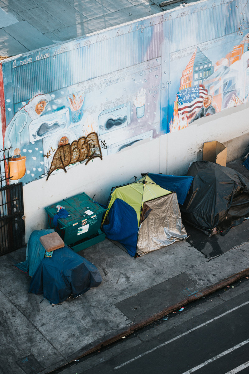 A row of tents on a city street where homeless people camp.